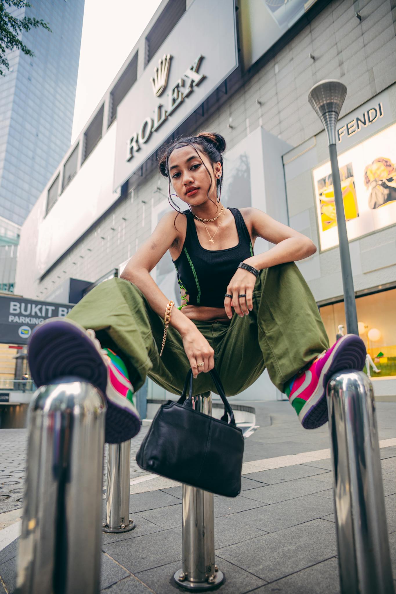 Young woman posing in city with stylish outfit and accessories, showcasing urban fashion.