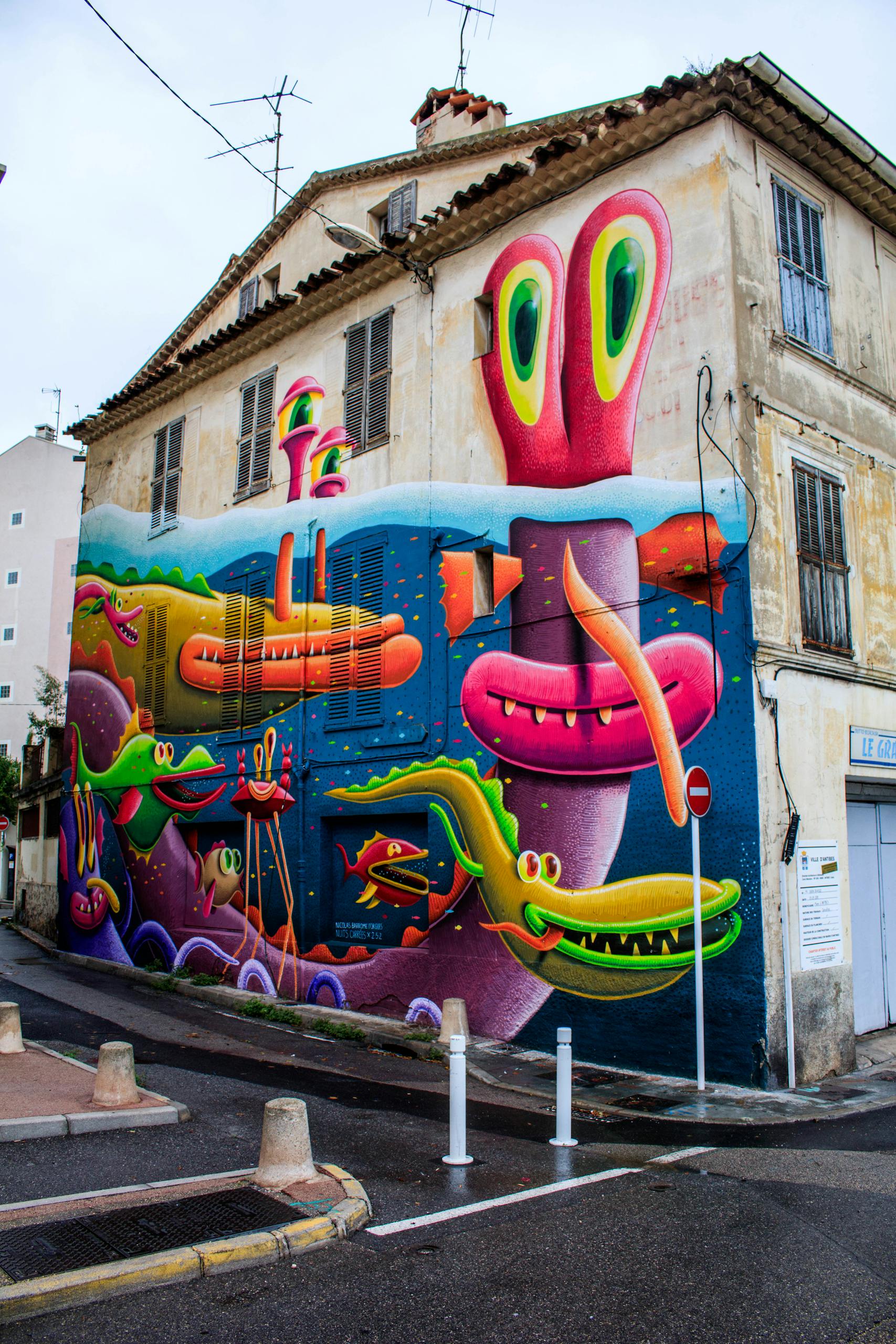 Colorful street art mural featuring monsters on a building wall in Antibes, France.