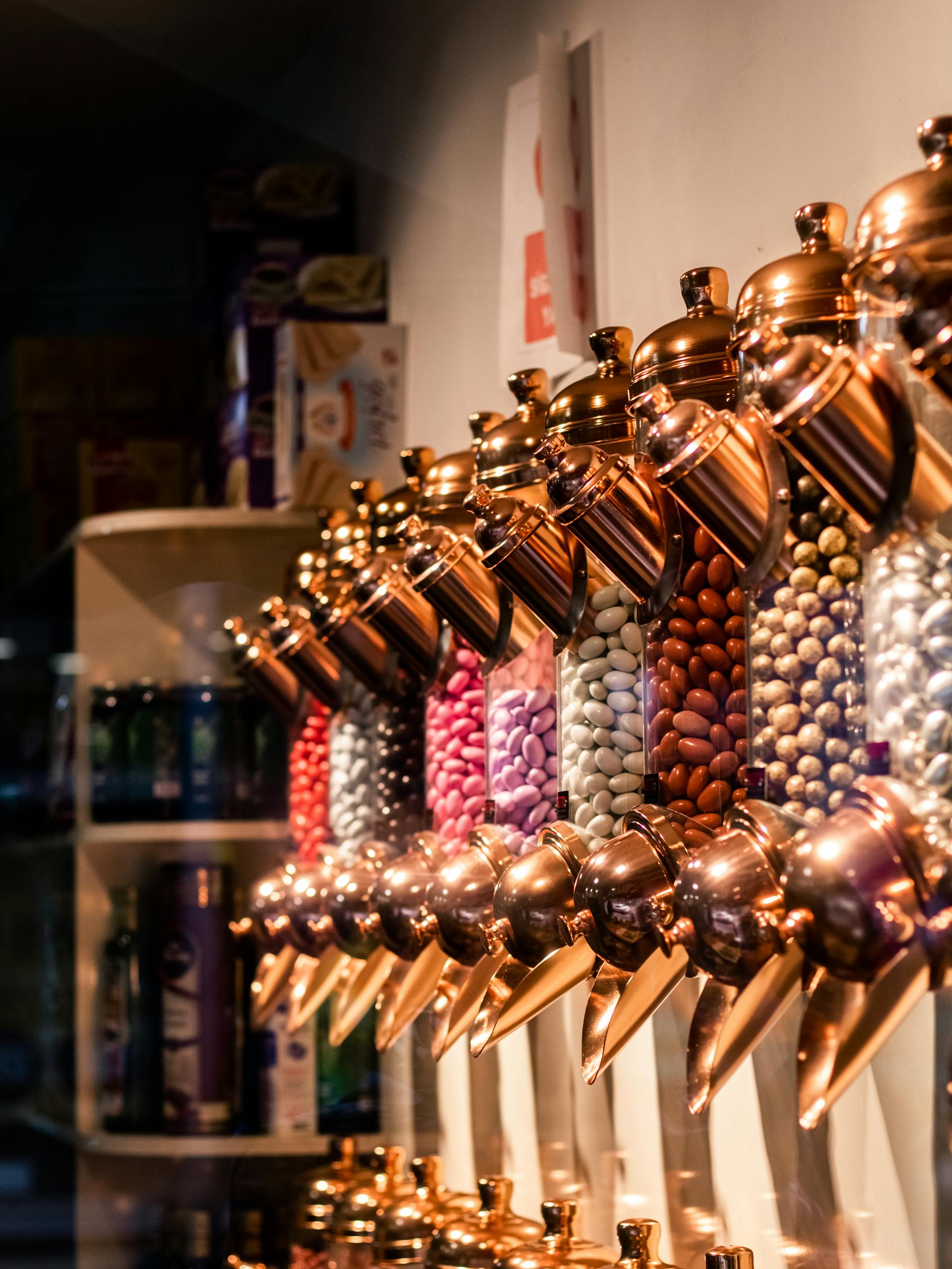 Vertical shot of colorful candy dispensers in a cozy candy store interior.
